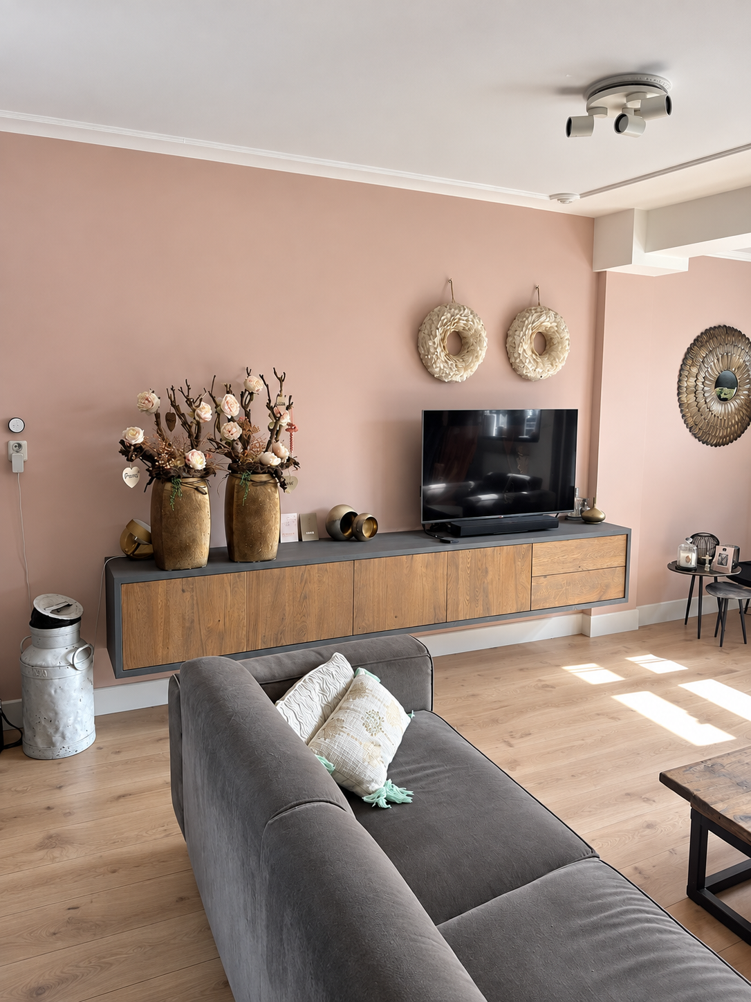 Woonkamer na het schilderwerk met een strak afgewerkte zalmroze wand